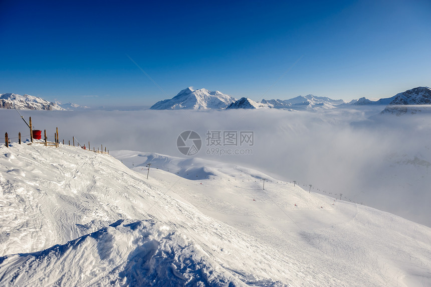 高山冬山景观低云阳光明媚的日子里,法国阿尔卑斯山上覆盖着雪瓦尔迪塞尔,法国图片