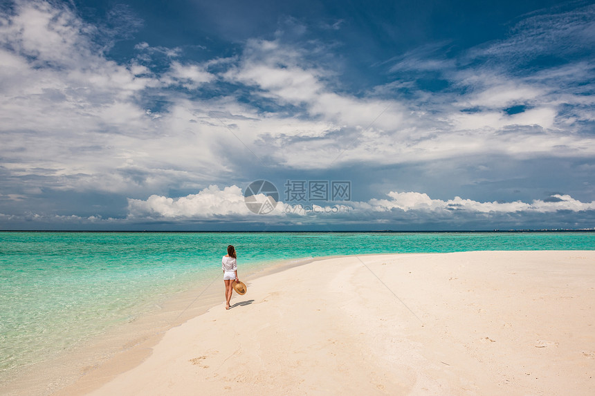 马尔代夫的热带海滩上戴着太阳帽的女人图片