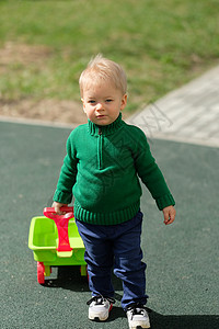 户外幼儿的肖像岁的小男孩穿着绿色毛衣操场上图片