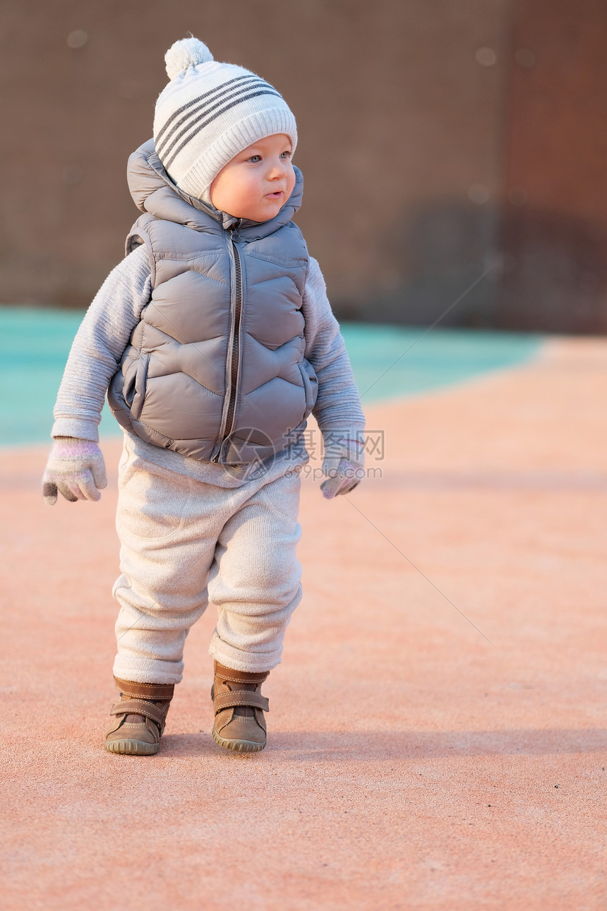 户外穿着温暖背心夹克的蹒跚学步的孩子的肖像岁的小男孩日落时穿着背心夹克操场上图片