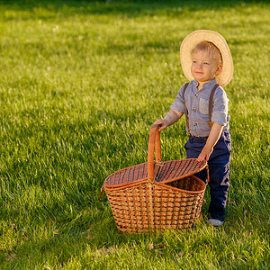 户外幼儿的肖像农村场景,岁的小男孩戴着草帽野餐篮图片