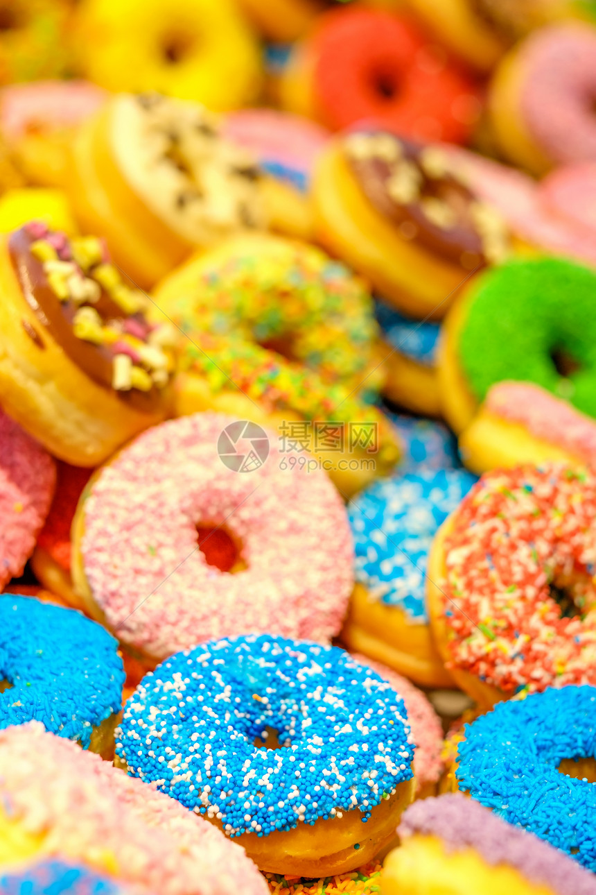 各种装饰甜甜圈蓝色粉红色甜甜圈甜冰糖食品甜点五颜六色的小吃釉洒水甜甜圈加霜场的浅深度图片