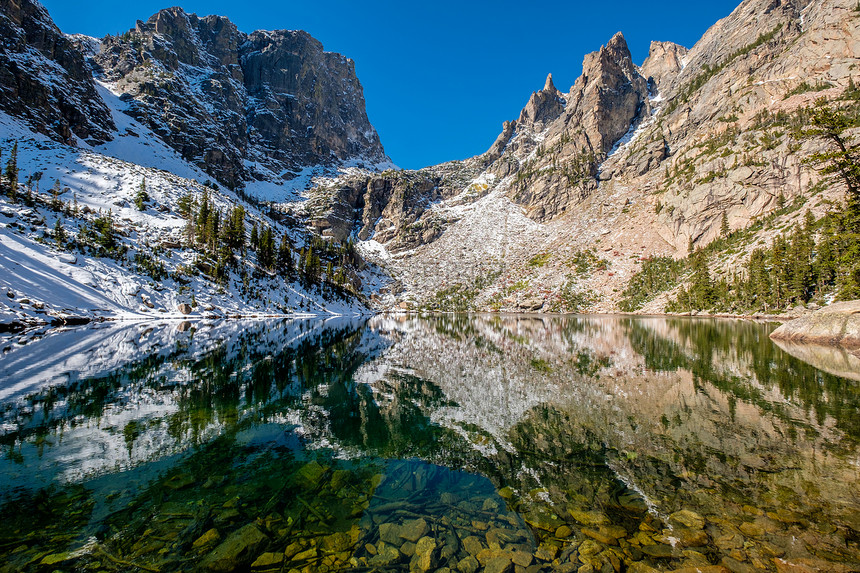 翡翠湖倒影与岩石山脉雪周围秋天美国科罗拉多州洛基山公园图片