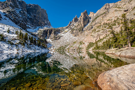 翡翠湖倒影与岩石山脉雪周围秋天美国科罗拉多州洛基山公园图片