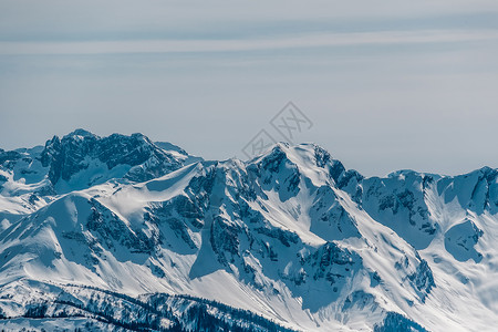 冬天的山景阳光明媚的日子里,高加索山脊上覆盖着雪克拉斯纳亚多拉那,索契,俄罗斯背景