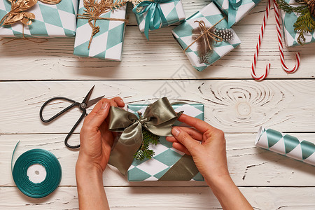 女人包装诞礼物创造地包装装饰诞礼物盒子上的木制背景顶部的视图图片