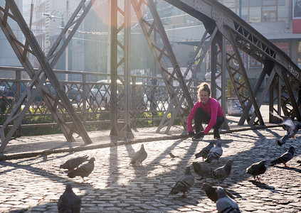 运动的女人跑步人行道上清晨慢跑与城市日出的背景图片