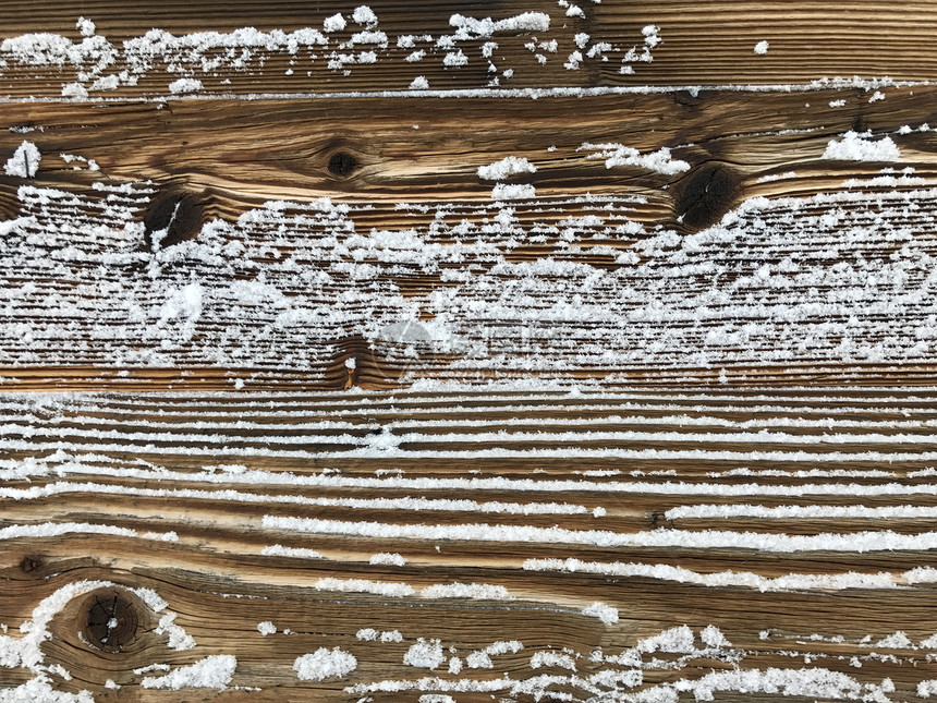 古老的木墙覆盖着雪,复古的自然户外背景图片