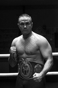 肌肉专业踢拳运动员的肖像与他的冠腰带训练环图片