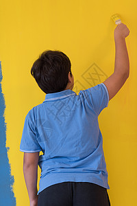 位轻男孩画家的肖像,他的手彩色背景前着画笔图片