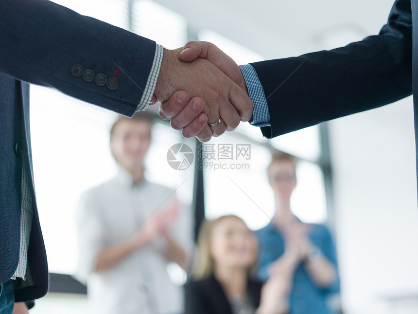 商业伙伴现代办公楼的会议上握手图片