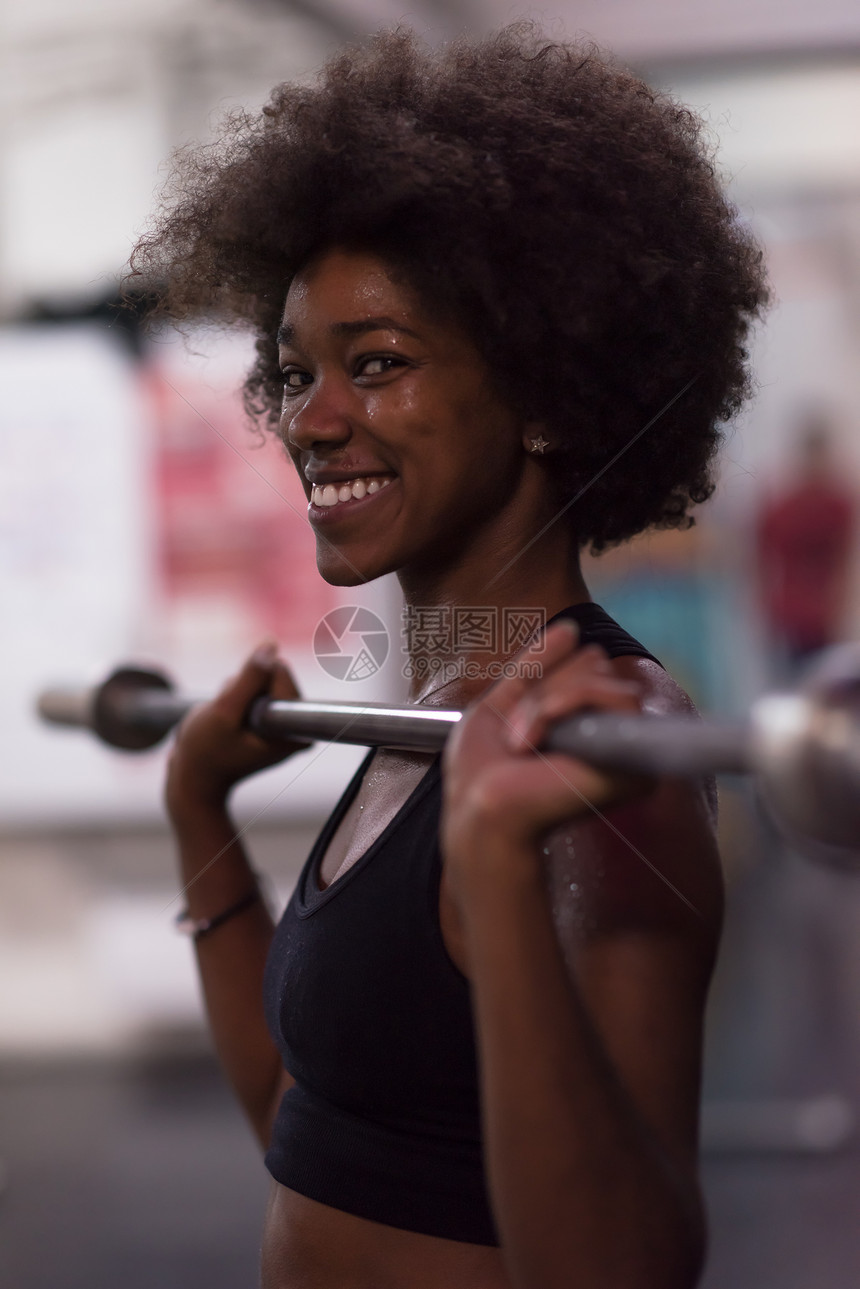 轻可爱的非裔美国运动妇女健身房举空酒吧图片