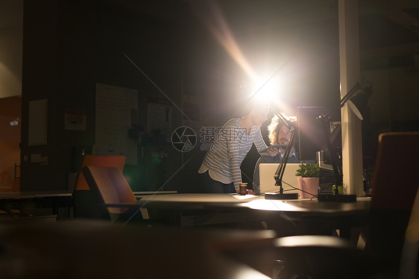 两位轻的师正利用现代技术夜间办公室个新项目图片