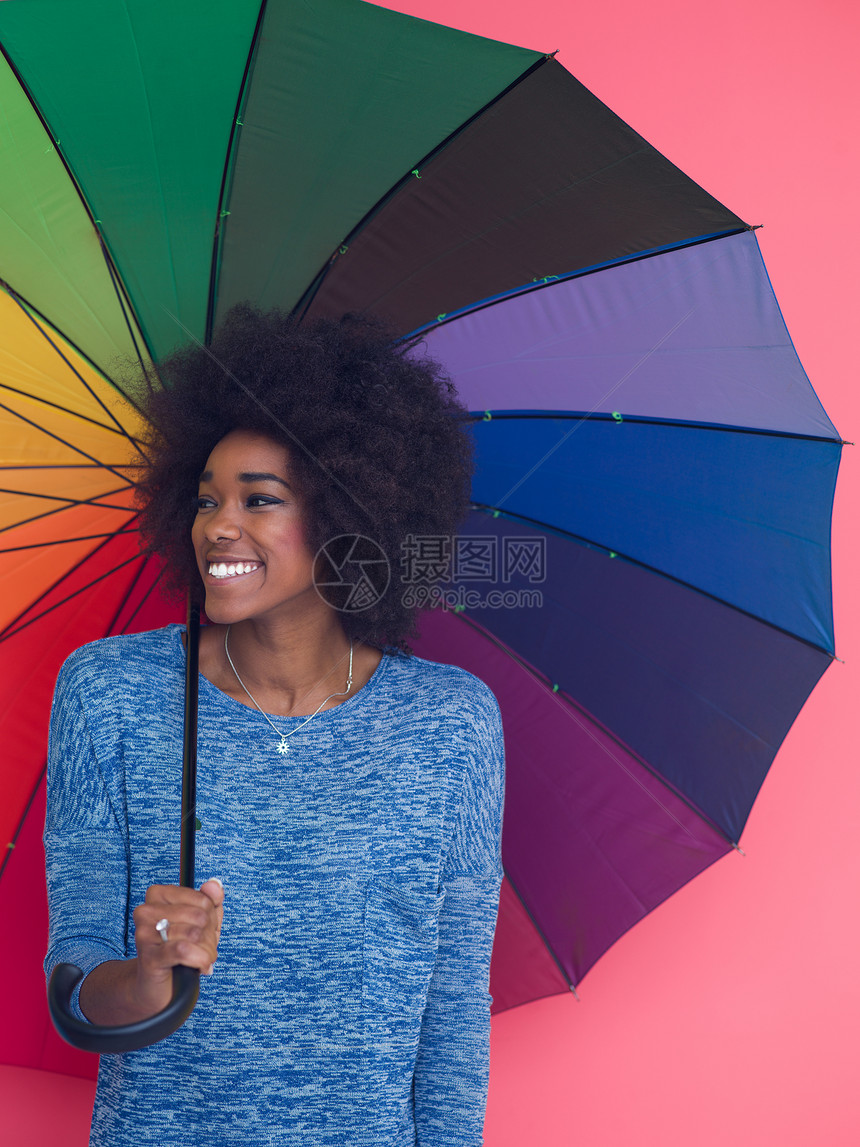 轻美丽的非裔美国妇女的肖像,着把五颜六色的伞,孤立粉红色的背景上图片