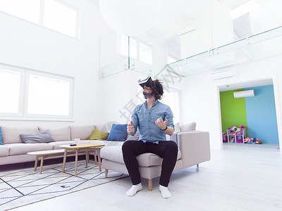 家校互动快乐的男人家里用虚拟现实的VR耳机眼镜获得经验设计图片