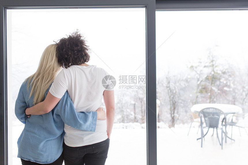 浪漫快乐的轻夫妇寒冷的冬天家窗边享受早晨的咖啡图片