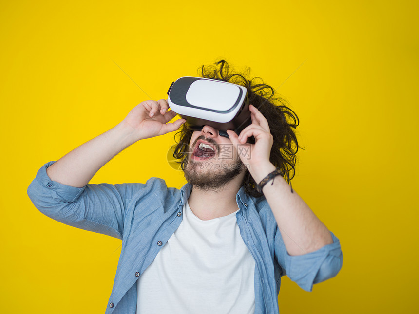 快乐的男人获得经验用虚拟现实的VR耳机眼镜,孤立黄色背景上图片