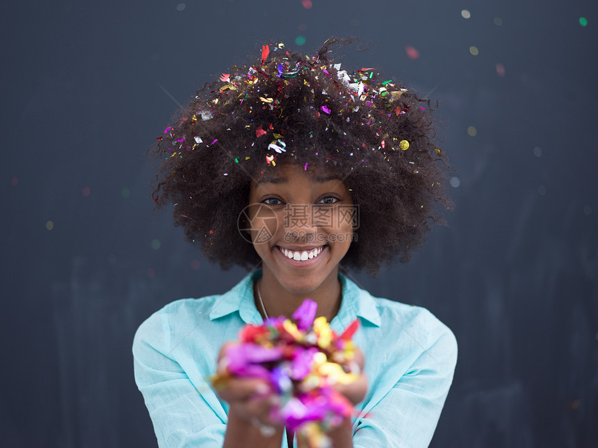 美丽的轻黑人妇女庆祝新诞派,同时纸屑装饰相机隔离灰色背景图片