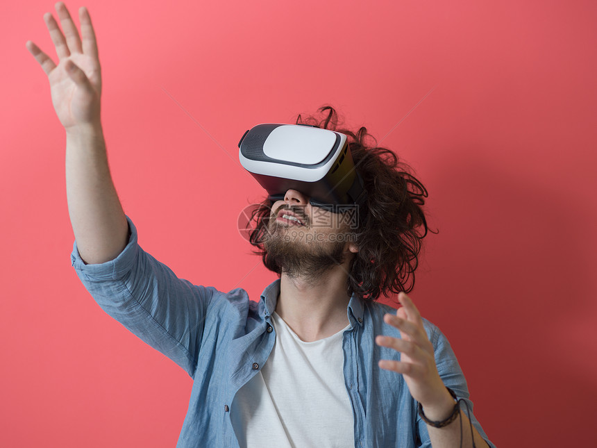 快乐的男人获得经验用虚拟现实的VR耳机眼镜,孤立红色背景上图片