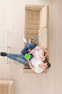 轻夫妇坐豪华客厅的沙发上,用平板电脑图片