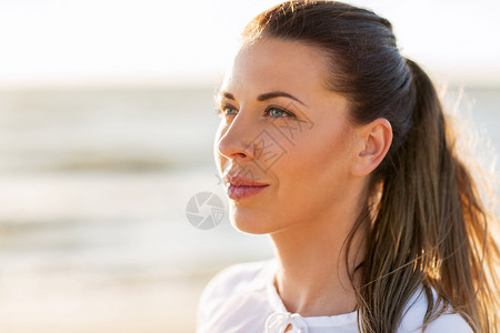 人,情感部表情的海滩上快乐微笑的轻女人的脸图片