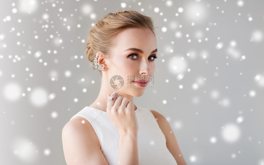珠宝,豪华,诞节,假日人们的微笑的女人穿着白色连衣裙,戴着钻石耳环,戒指灰色的背景雪上图片