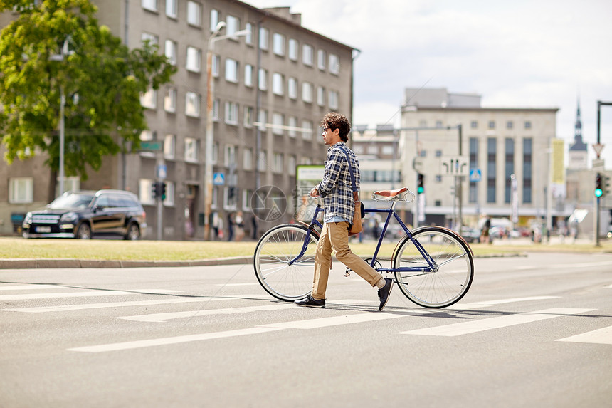 人,风格,城市生活生活方式轻的时尚男子肩袋固定齿轮自行车穿越人行横道街上图片