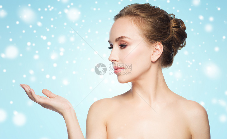 美丽,人,广告,冬天健康的轻的女人她的手掌上着蓝色的背景雪图片