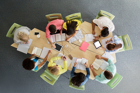 教育,高中,人技术群国际学生坐桌子上,平板电脑电脑,书籍笔记本顶部大学图书馆图片