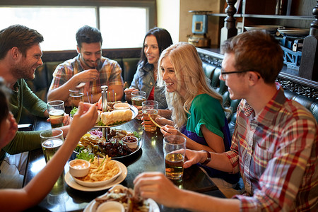 休闲,饮食,食物饮料,人假日的微笑的朋友餐馆酒吧吃晚餐喝啤酒图片