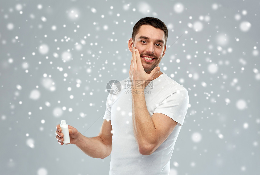 美丽,护肤,冬天,诞节人们的微笑的轻人灰色背景上的雪上涂奶油乳液图片