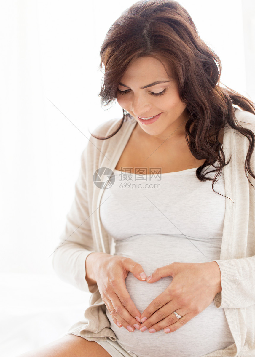 怀孕,爱,人期望的快乐的孕妇家里心脏手势图片