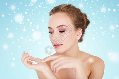 美丽,人,护肤品,冬天化妆品的快乐的轻女人与保湿霜蓝色背景雪图片