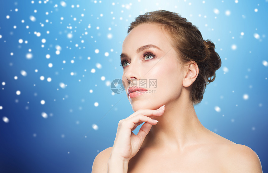 美丽,人,冬天健康的美丽的轻女人触摸她的脸蓝色的背景雪图片