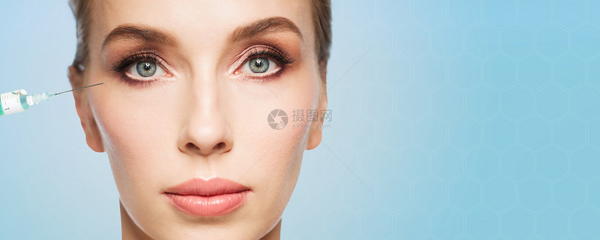 人,美容,整形,抗衰容美丽的轻女人的脸注射器注射眼睛区域的蓝色背景图片