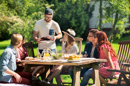 休闲,假期,饮食,人食物的快乐的朋友夏季花园聚会上吃肉背景图片