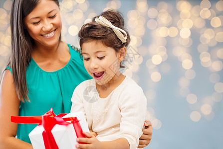 诞节,假日,庆祝,家庭人的快乐的母亲孩子女孩与礼品盒灯光背景图片