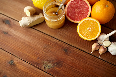 传统医学烹饪食品民族科学蜂蜜柑橘类水果,以生姜大蒜为木质背景图片