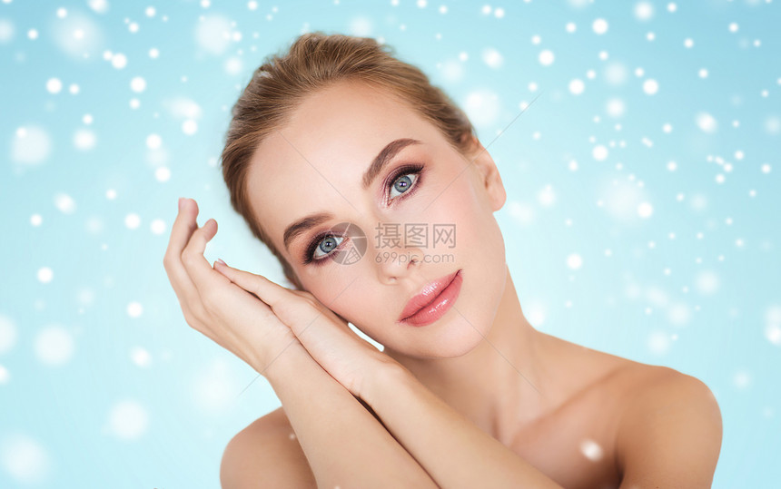 美丽,冬天,人身体护理的美丽的轻女人的脸手蓝色的背景雪图片