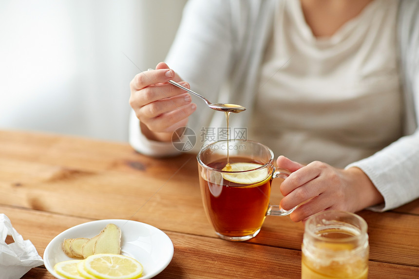 健康传统医学民族科学木桌上用柠檬蜂蜜生姜喝茶的病妇图片