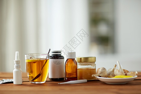 医疗保健,传统医学流感药物,温度计,蜂蜜木制桌子上的杯茶图片