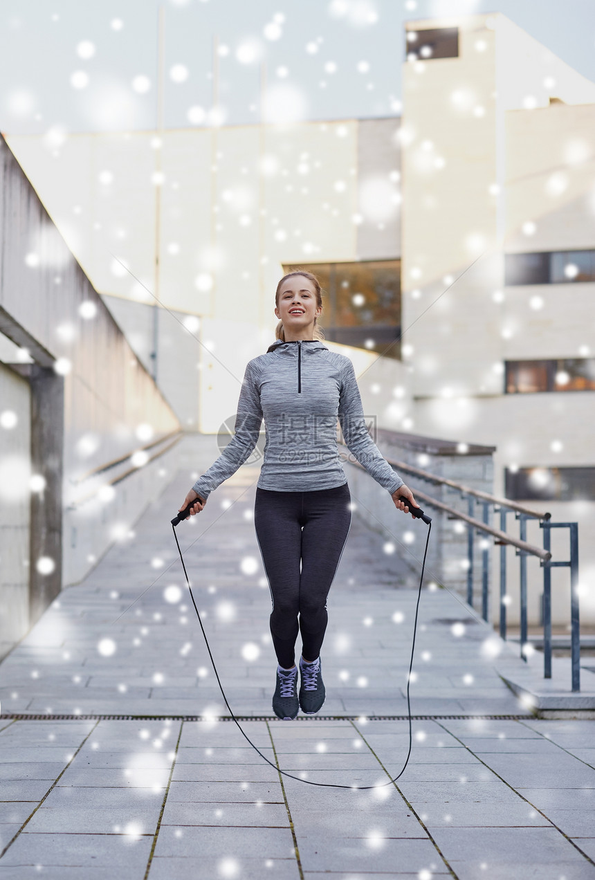 健身,运动,人,锻炼健康的生活方式快乐的女人跳绳户外雪图片