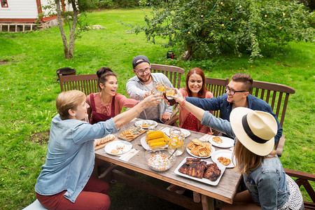 休闲,假期,饮食,人食物的快乐的朋友碰杯庆祝夏季花园聚会图片