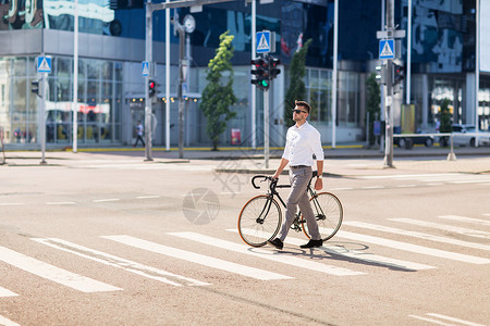 人,风格生活方式的轻人骑自行车穿过人行横道城市街道图片