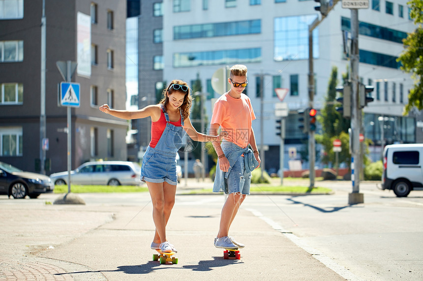 暑假,极限运动人们的快乐的青少夫妇骑着短的现代巡洋舰滑板城市街道图片