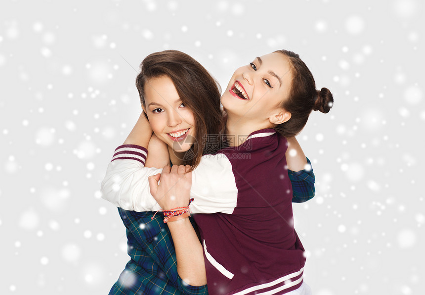 冬天,诞节,人们,青少友谊的快乐的微笑,漂亮的十几岁的女孩朋友拥抱灰色的背景雪图片