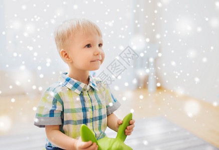 童,玩具人的快乐的小男孩玩骑玩具马家里下雪图片