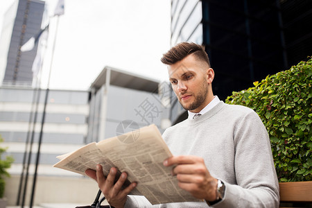 商业,大众媒体人们的男人城市街道长凳上阅读报纸图片