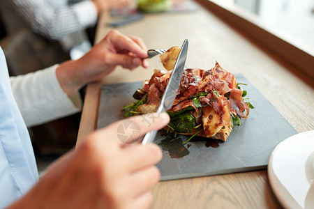 食物,晚餐人们的女人餐厅的石板上吃火腿沙拉图片