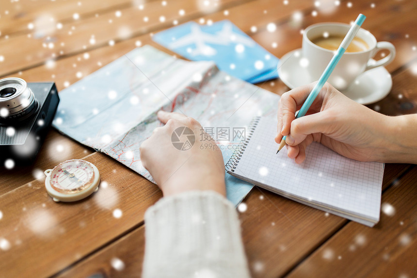 寒假,旅游,目的地人的旅行者的手与咖啡写笔记本上的雪图片